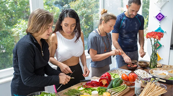 Participants preparing food together in a cooking group
